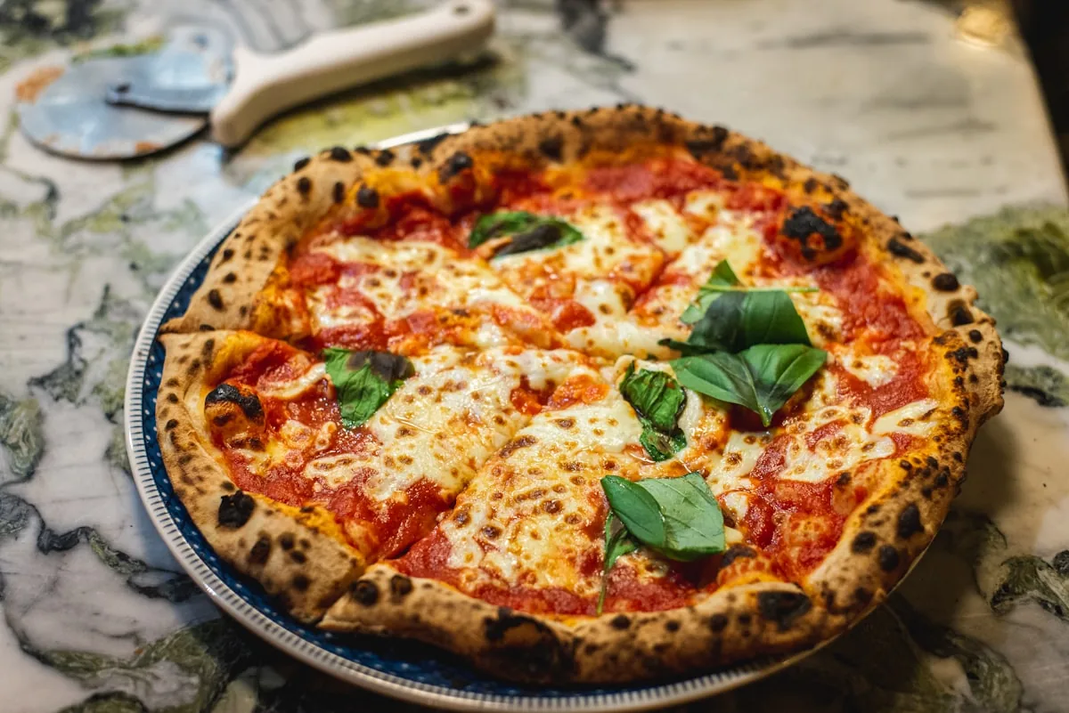 A coal-fired pizza with a blistered, airy crust